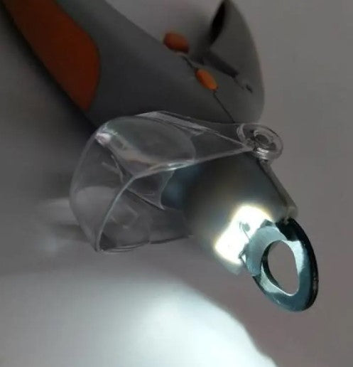Close-up of a pet nail trimmer with an illuminated cutting opening and clear guard