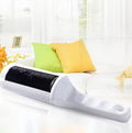 White reusable pet hair remover with black lint-collecting brush surface on a white sofa