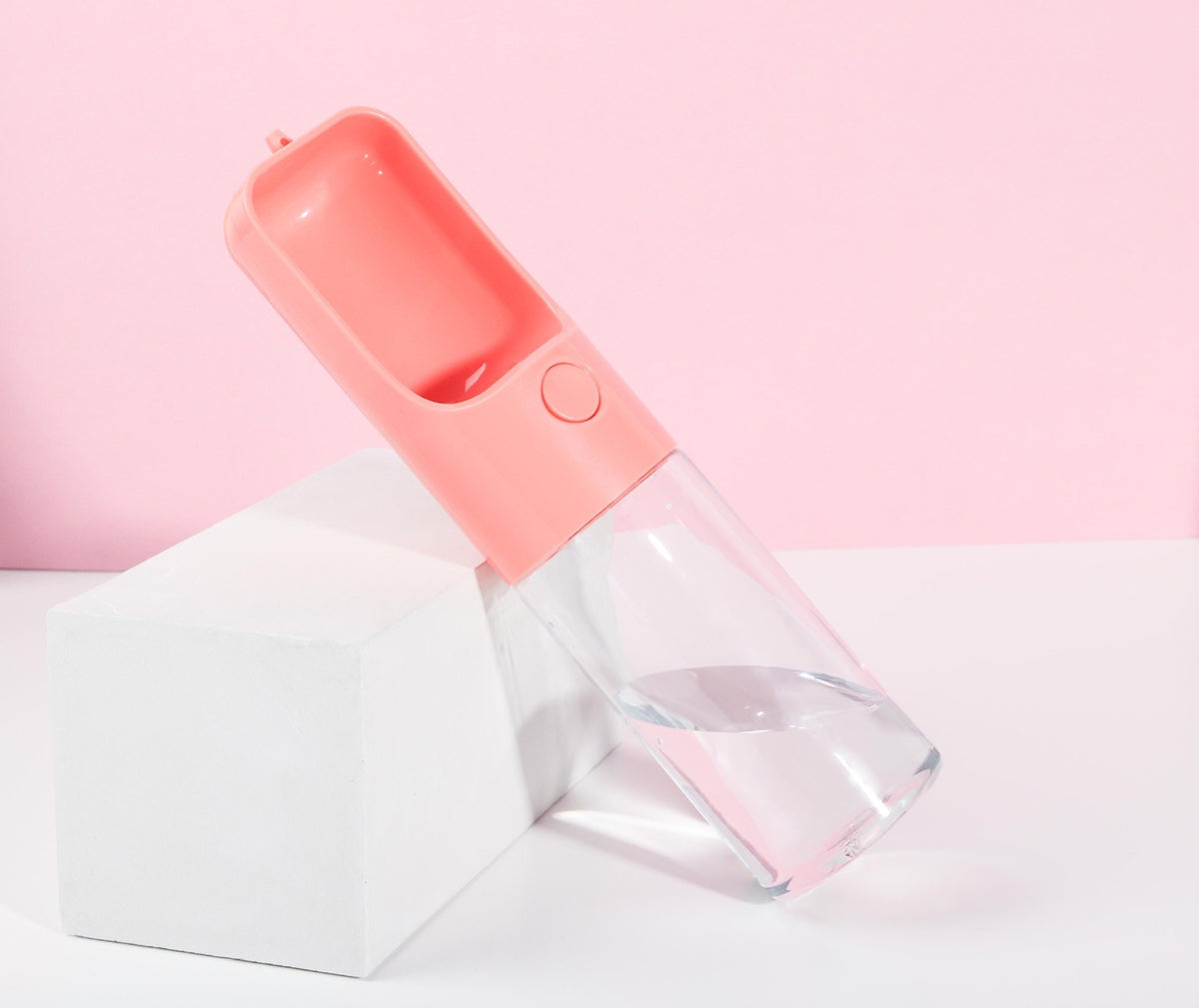 Pink pet travel water bottle with built-in drinking cup and clear reservoir